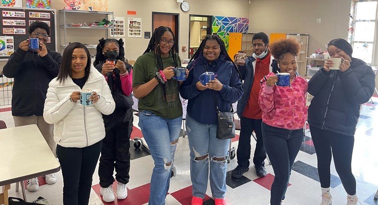 Students Showing Mugs they made in Ceramics Class