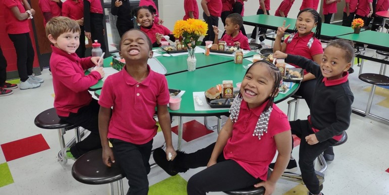 Students smiling at lunch table